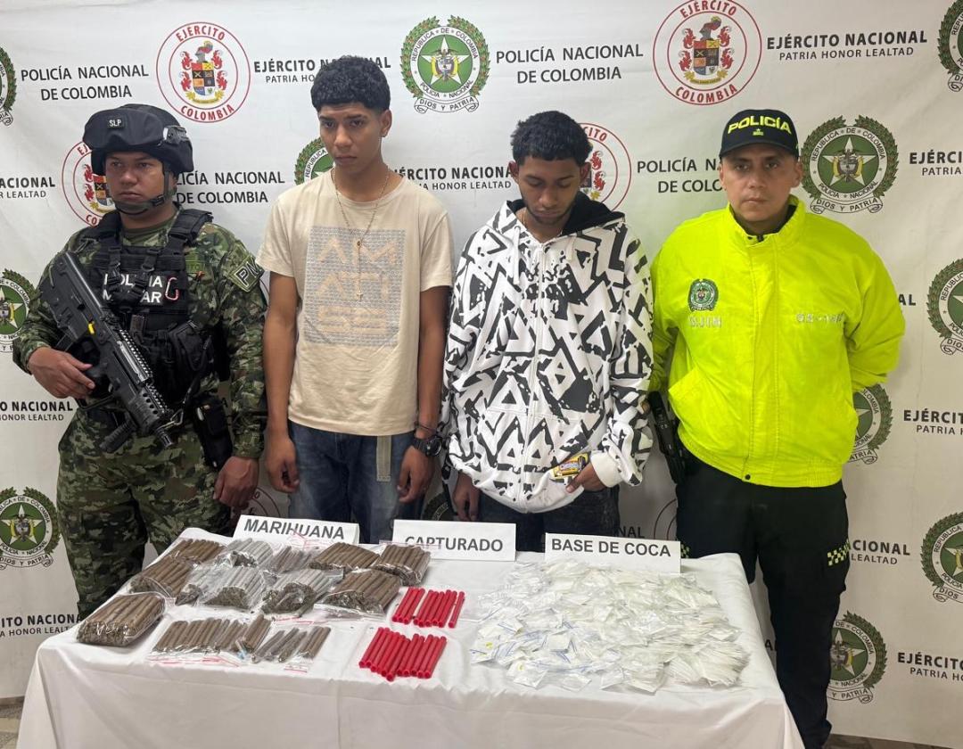 Dos hombres capturados y a sus lados policías 