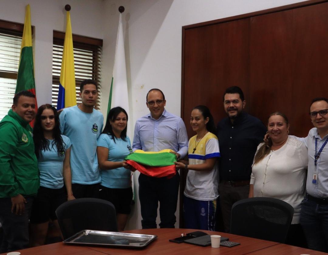 Alcalde con deportistas y la bandera de la ciudad