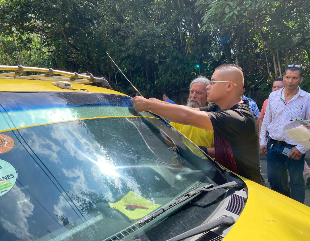 Taxistas de la ciudad poniendo el stiker 