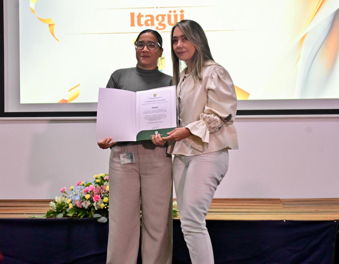 Secretaria de salud en el escenario recibiendo el reconocimiento por parte de la Gobernación de Antioquia